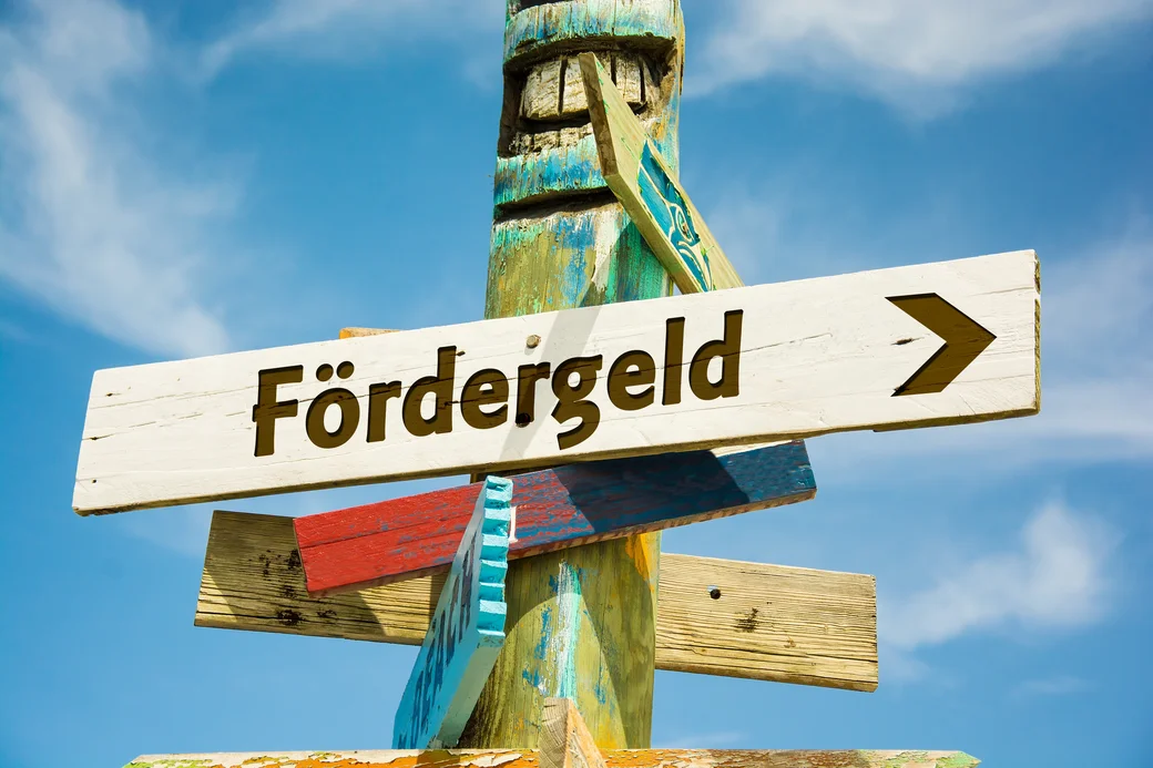 Der Begriff “Fördergeld” steht auf einem Wegweiser-Schild