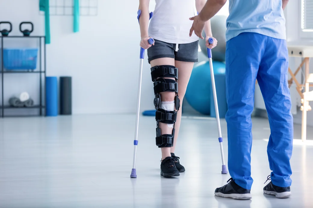 Patientin wird von Physiotherapeuten unterstützt.