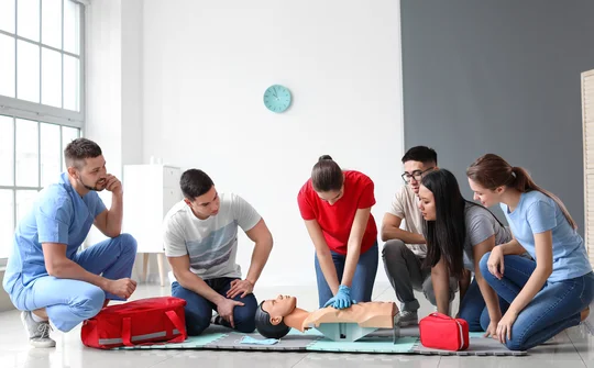 Lerngruppe bei der Herz-Druck-Massage an einer Puppe