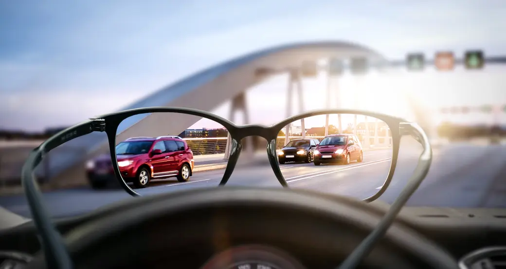 Man sieht Autos durch eine Brille