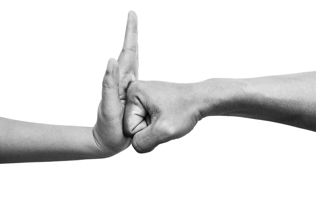 Geballte Faust trifft auf erhobene Hand